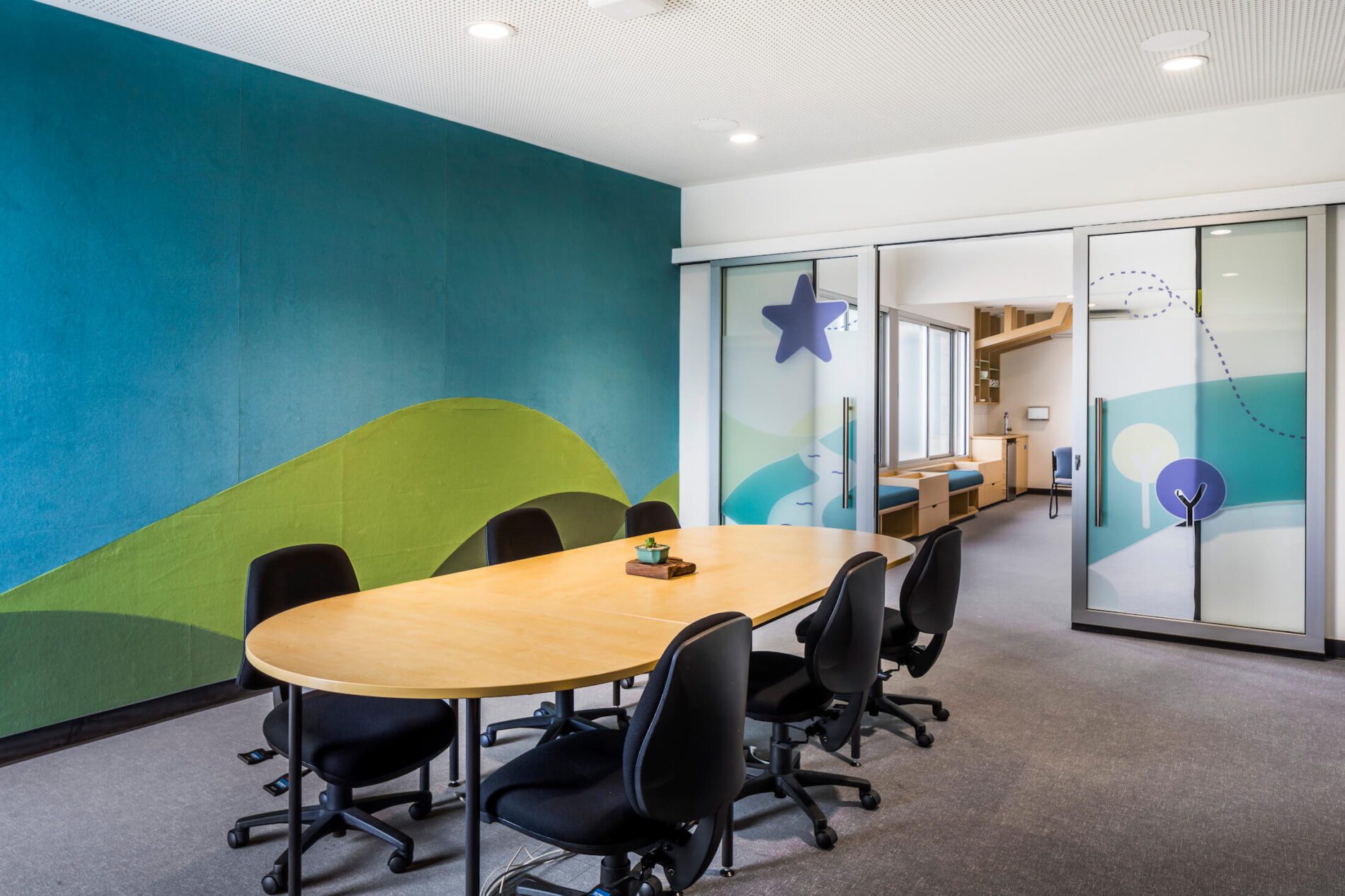 Boardroom with table and chairs, and tactile wall mural