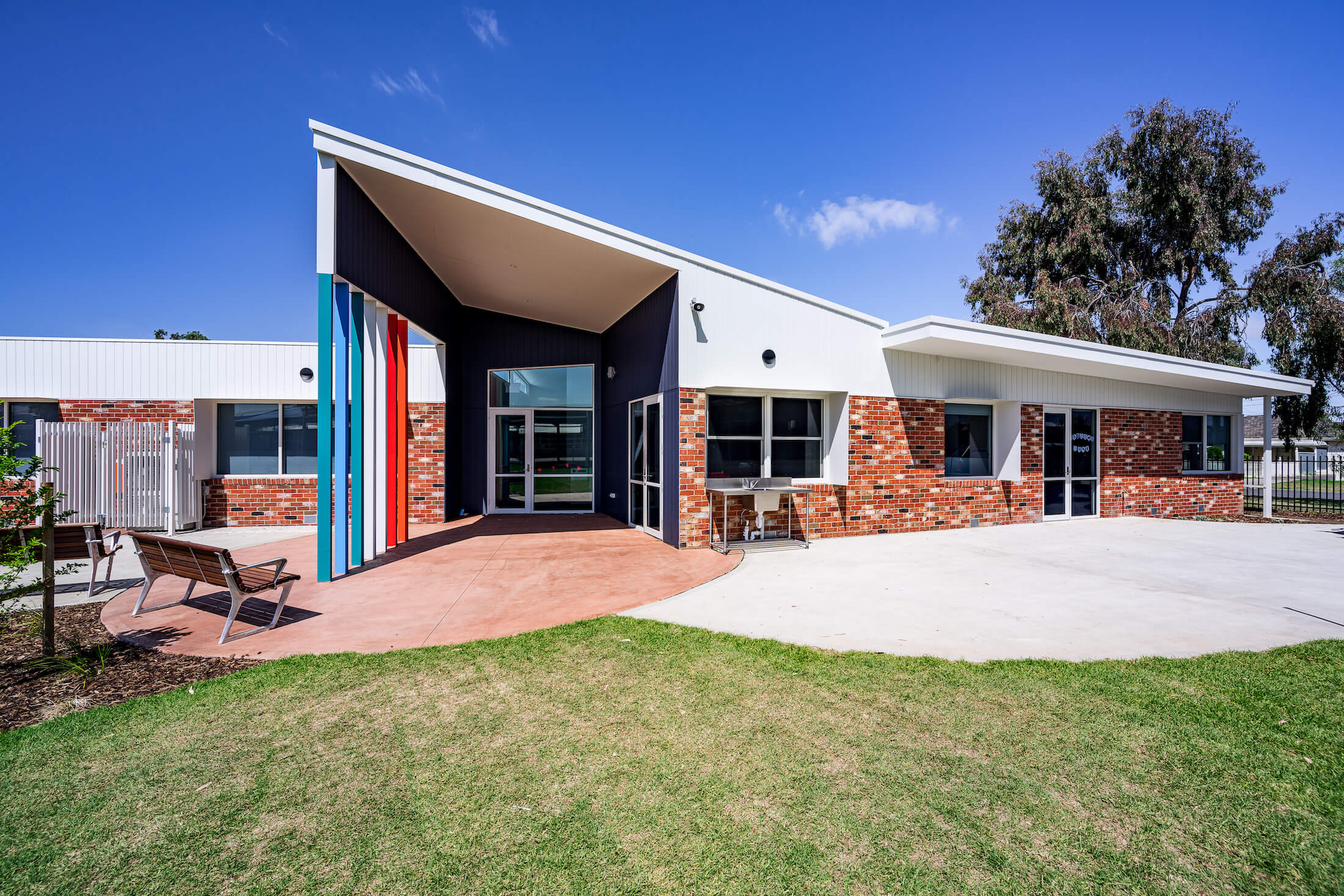 Brick school entry with colourful feature and angular canopy