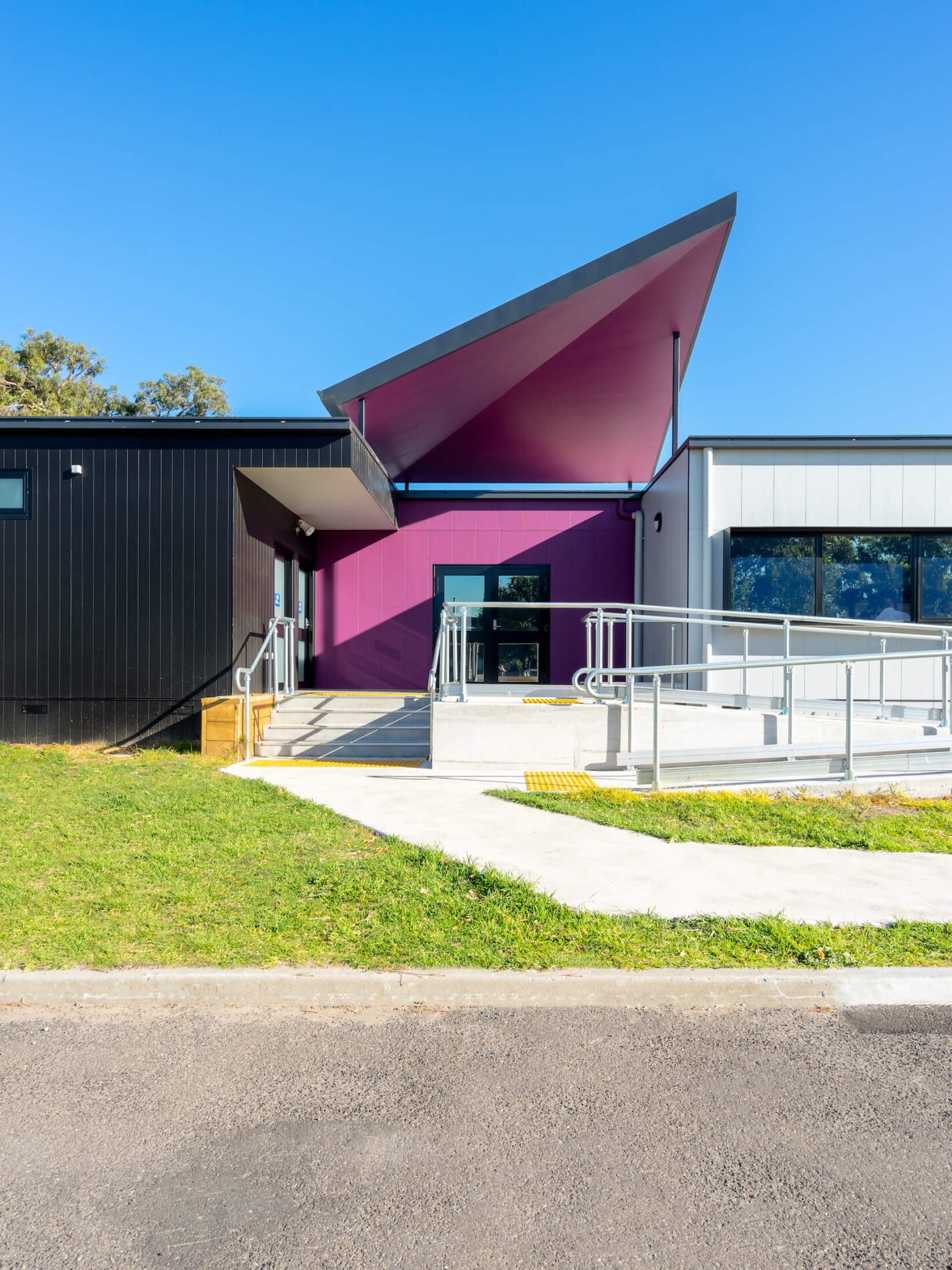 Permanent modular school building entry with purple angular canopy
