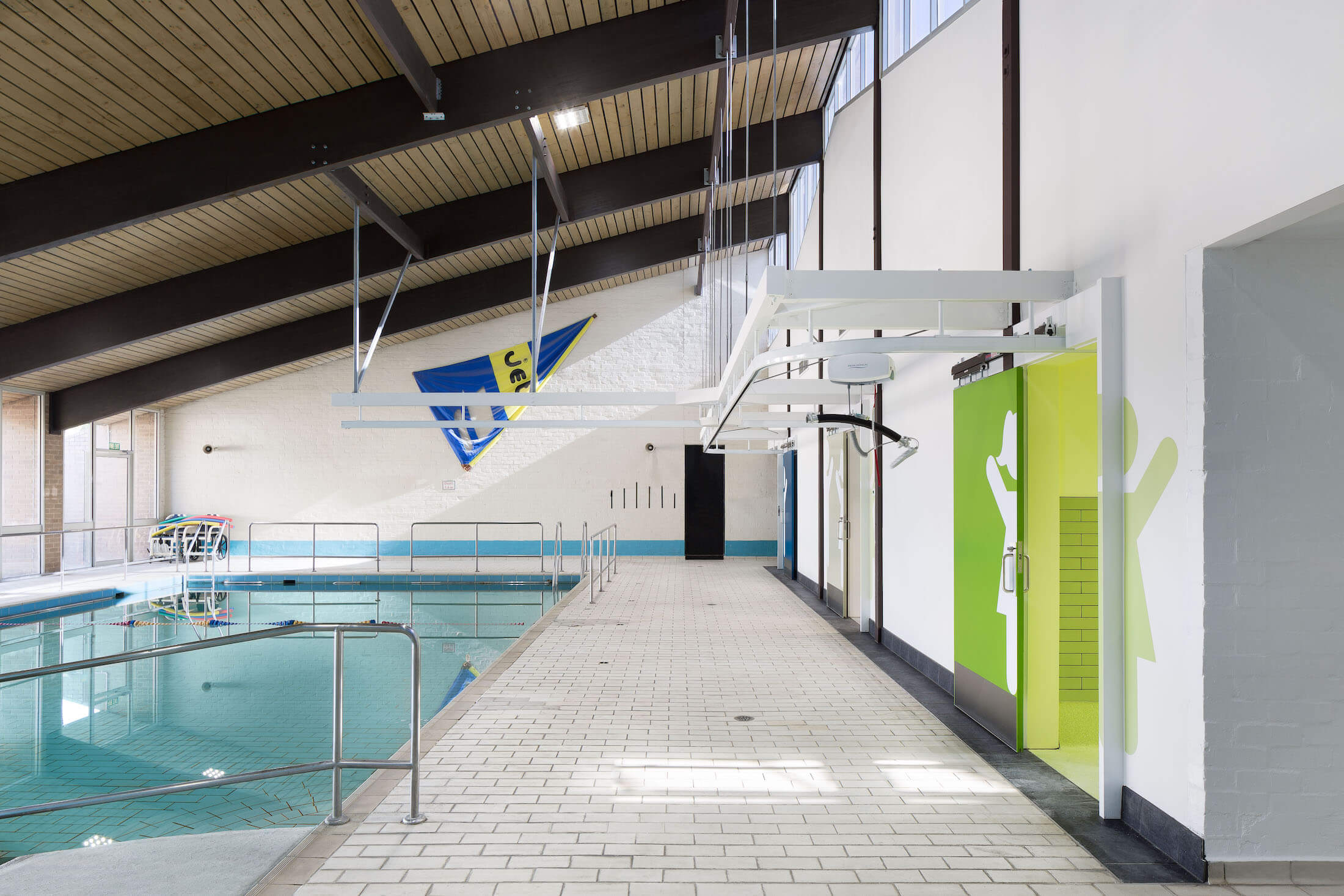 School pool area with colour coded toilet blocks and hoist tracks over pool