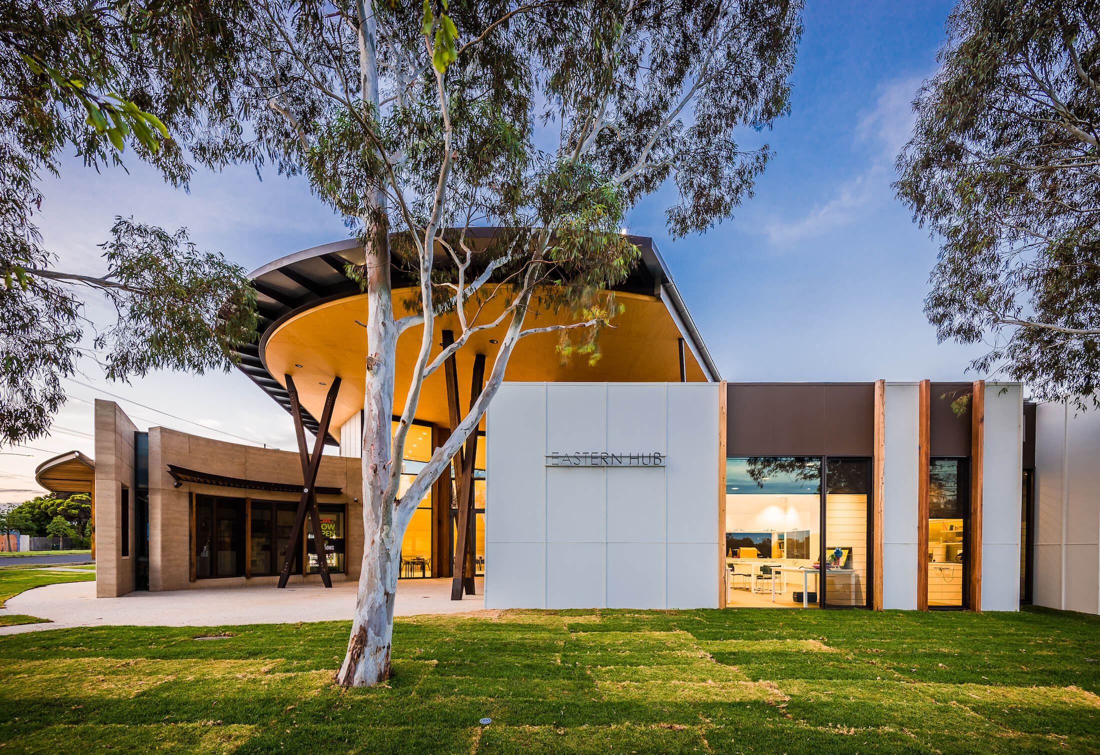 Front view of Eastern Hub community centre with canopy over forecourt and gum trees in the lawn