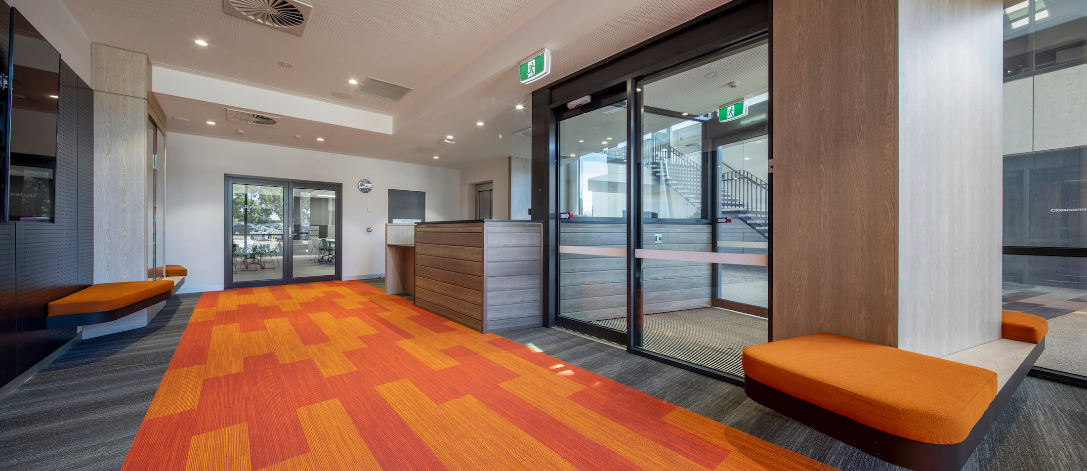 Foyer to Victoria Police Academy with orange feature wayfinding carpet detail and orange bench seating