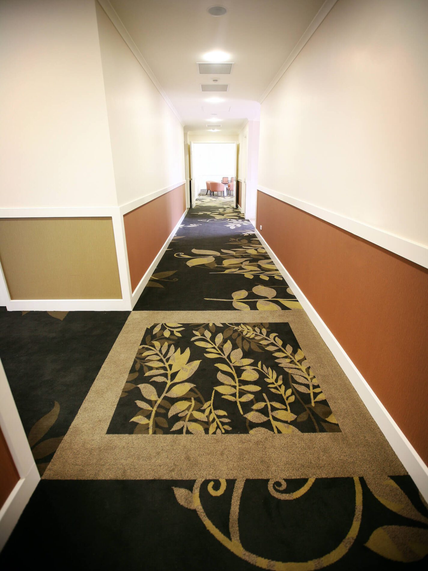 Carpeted with leaf motifs in hallway with dado rail and lounge beyond
