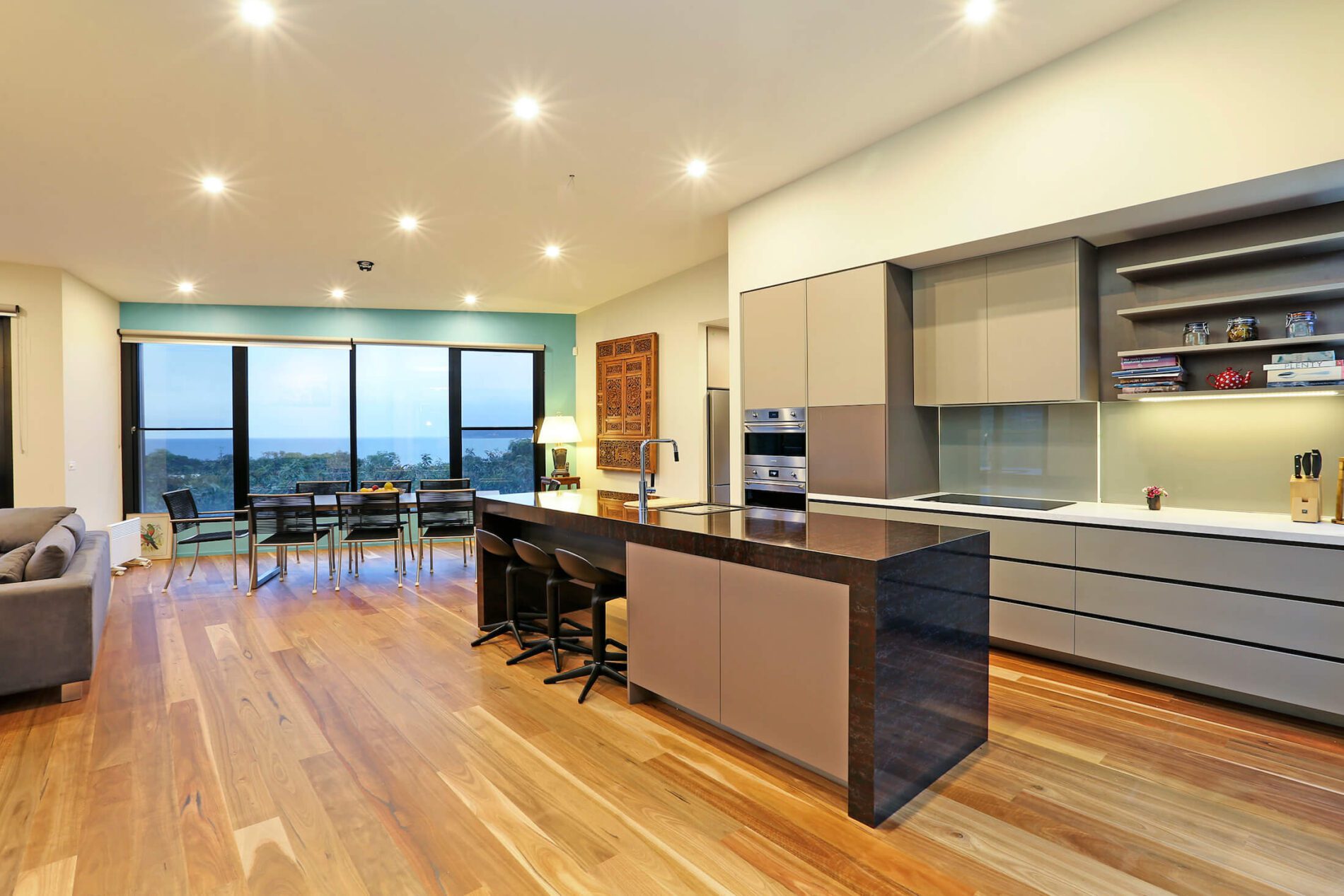 Open plan kitchen, dining, living with timber floors and views of ocean