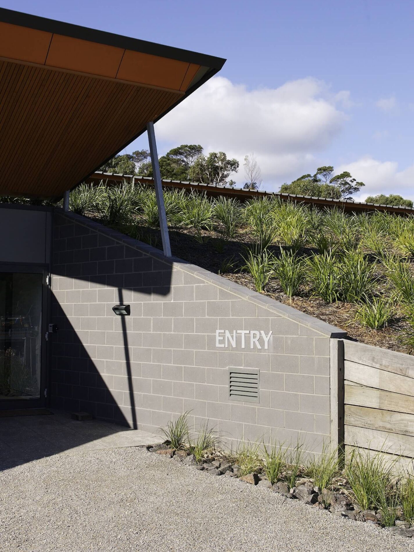 Canopy over Besser block wall entry and grassy landscaping