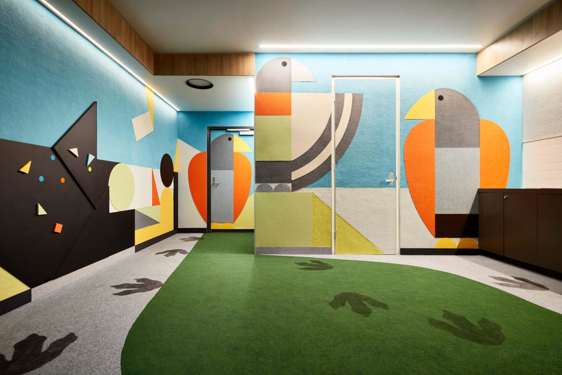 Colourful felt pictures applied to walls and flooring of foyer in eagle designs