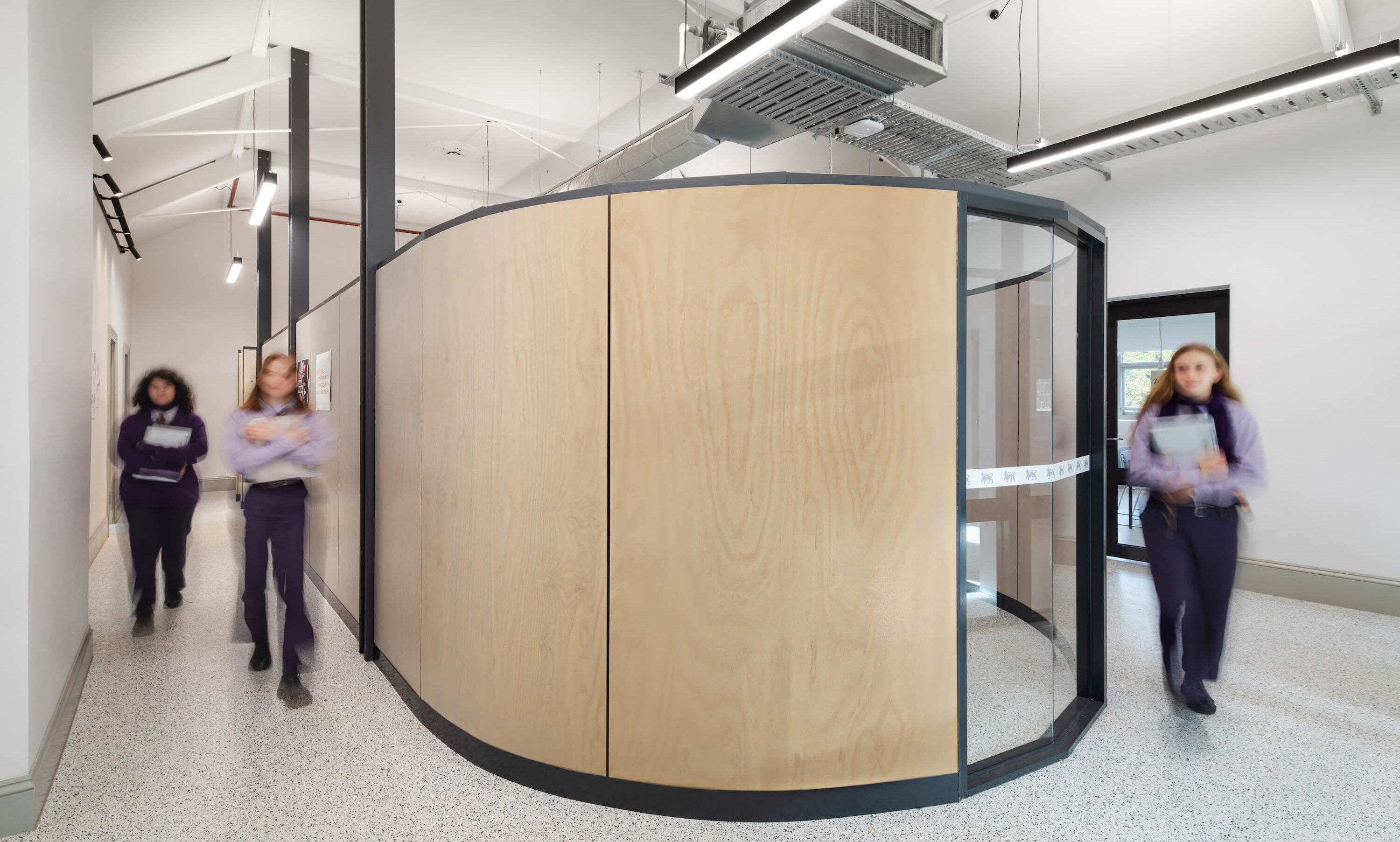 Students round a contemporary central pod in a heritage building