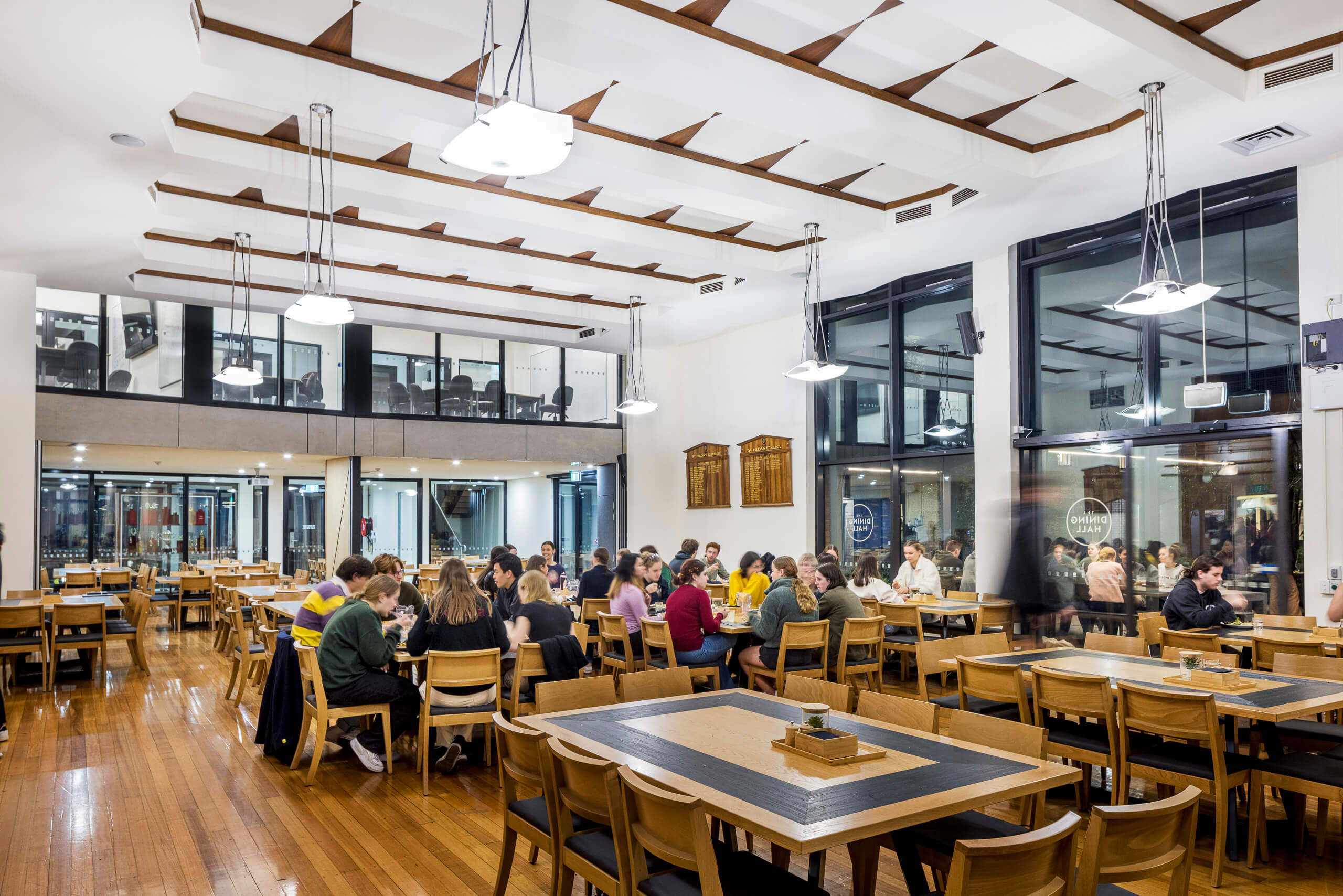 Large student dining hall with suspended pendants and inlay ceiling