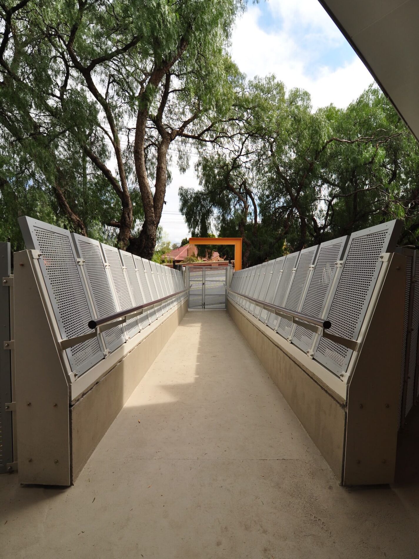 Safety bridge between complex and street with peppercorn trees overlooking