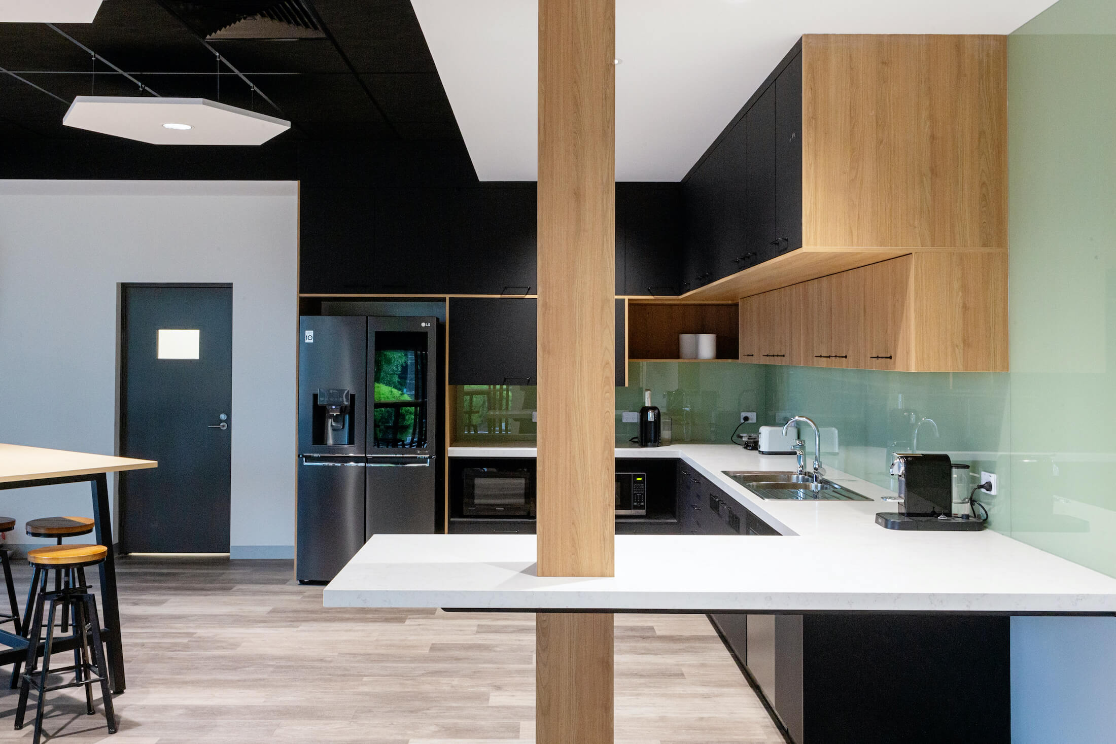 Contemporary kitchen space with black and timber look veneer joinery
