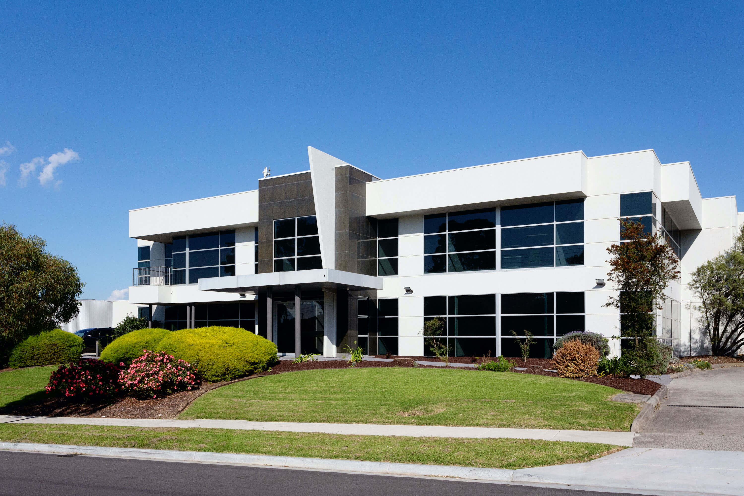 White commercial building with landscaped front