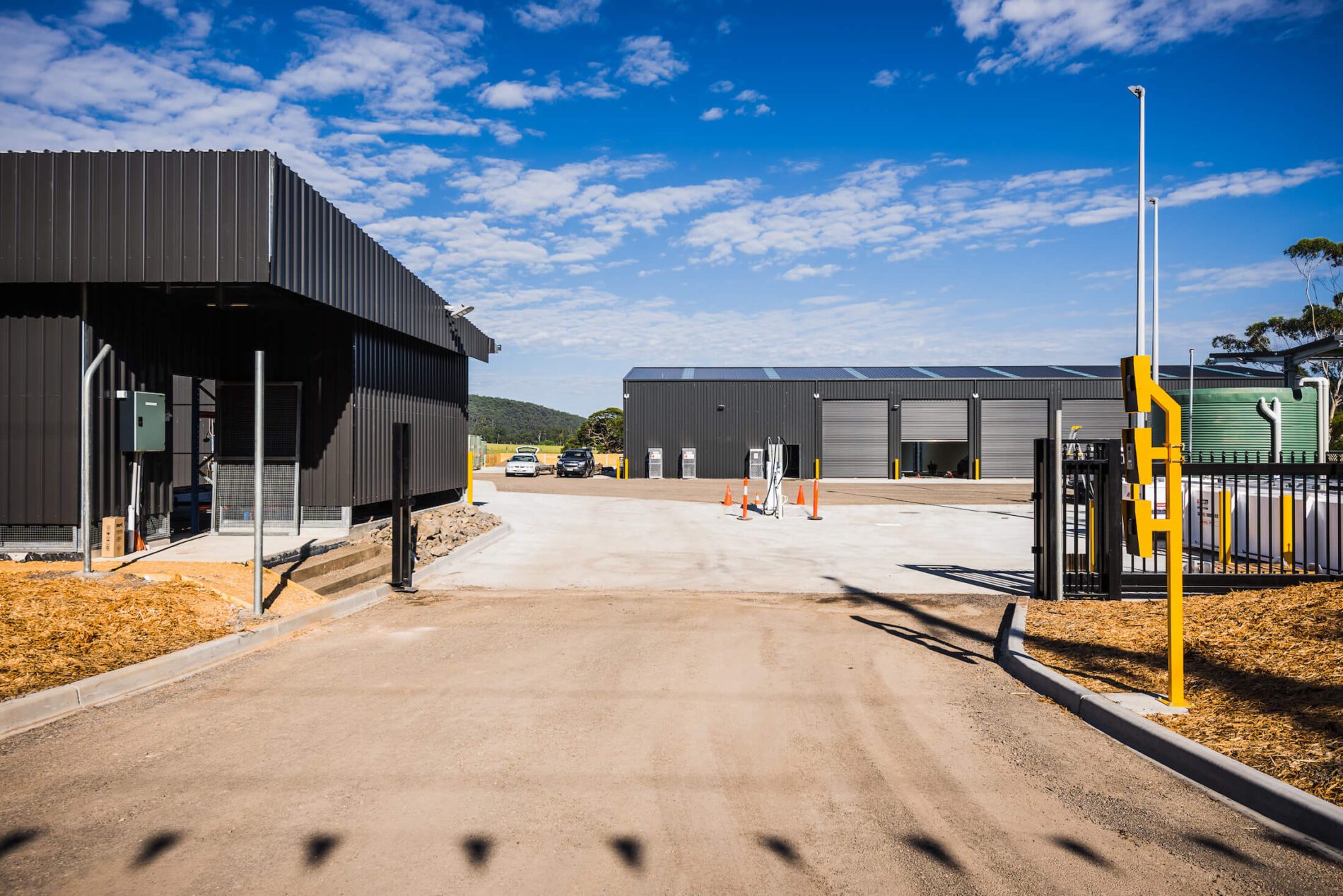 Industrial depot with black metal cladding, industrial sized shedding, open black gate