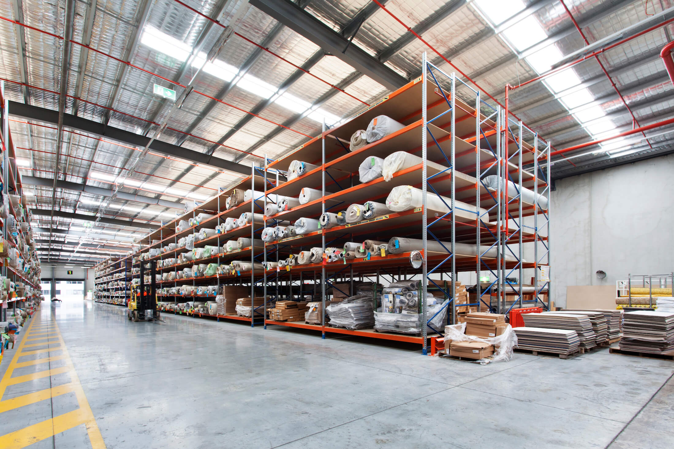 Carpet rolls on large shelving units in warehouse