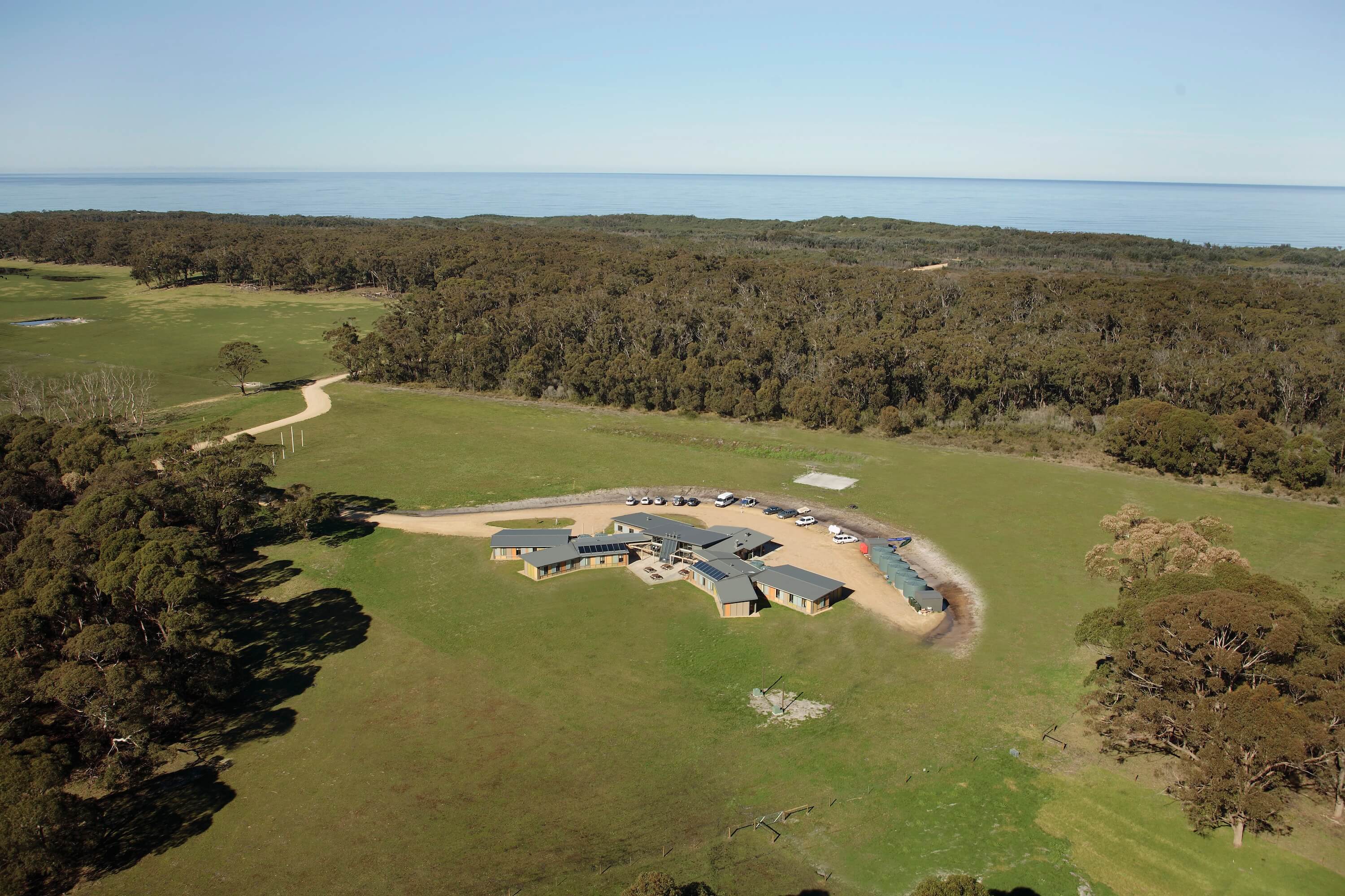 Wider aerial view of education facility in bushland by the sea