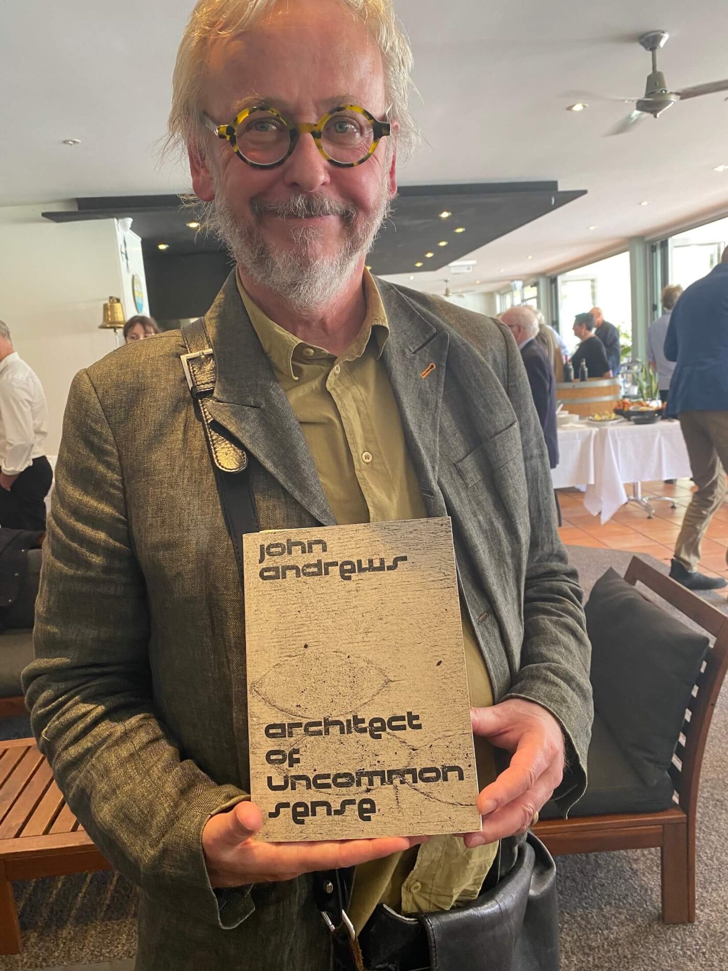 Professor of Architecture Paul Walker holds his book John Andrews: Architect of Uncommon Sense