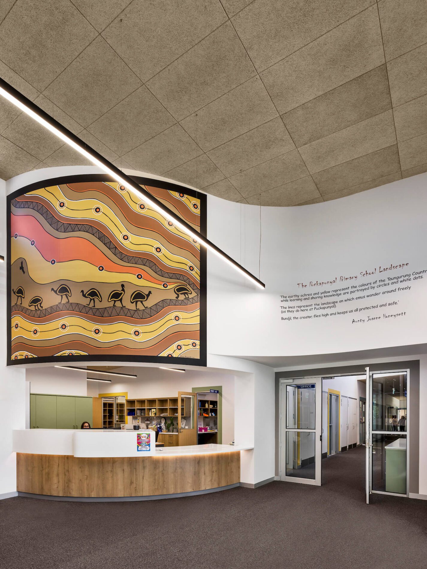 Curved school reception desk and large format Indigenous artwork above.