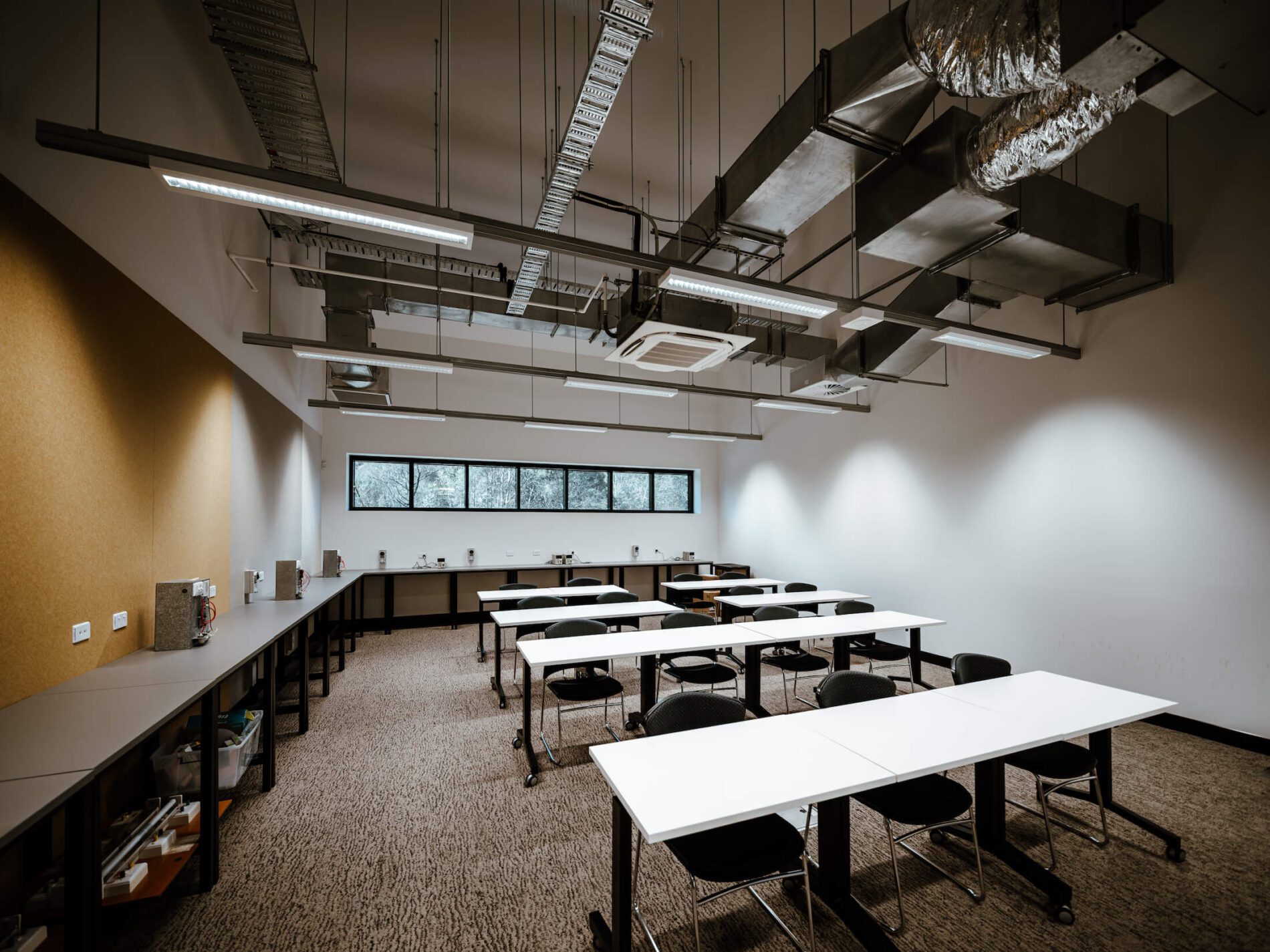 Classroom with coffee machines and tables and chairs in industry training facility.