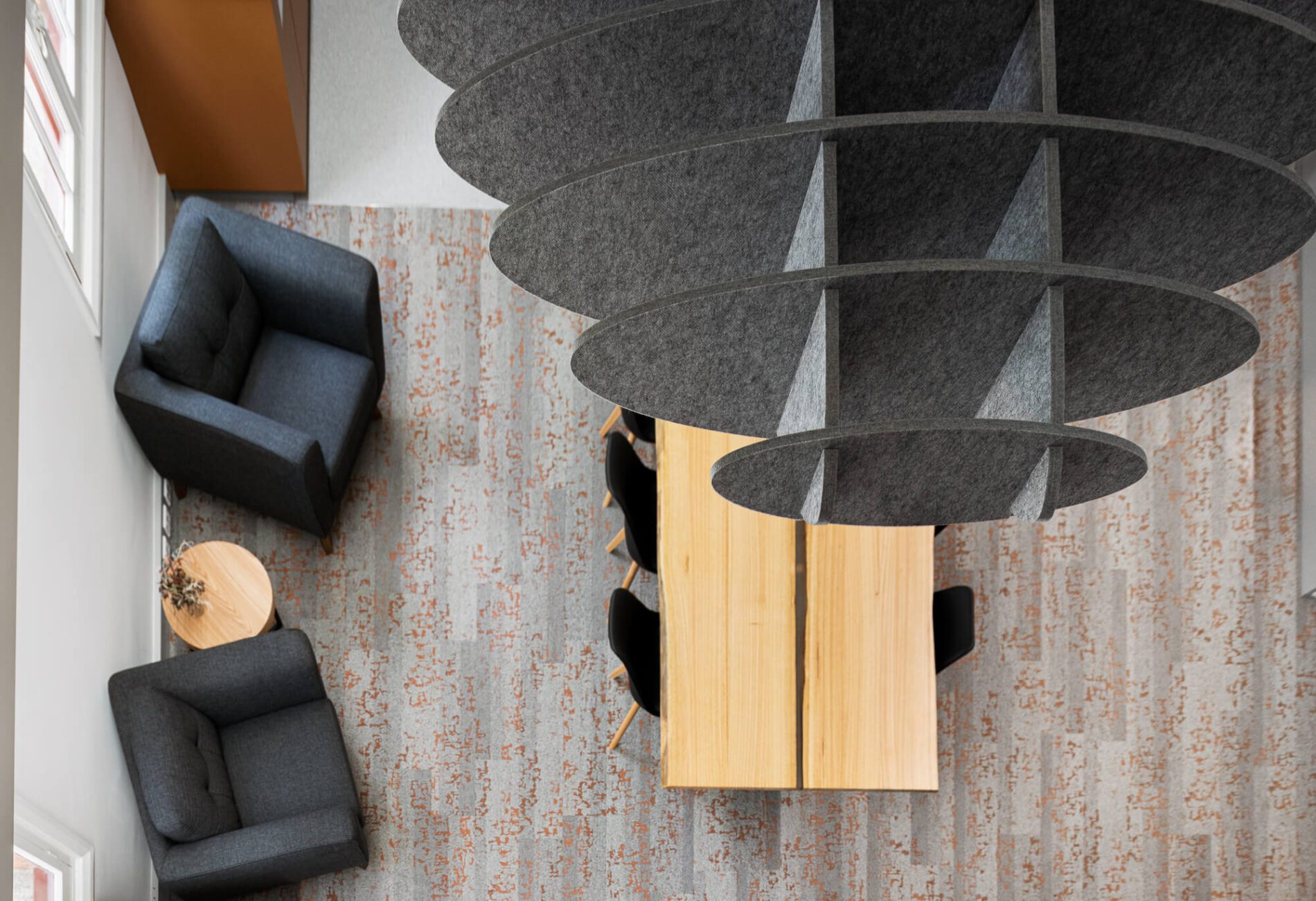 Birds-eye view of acoustic baffle above timber tables and club lounge seats in staffroom